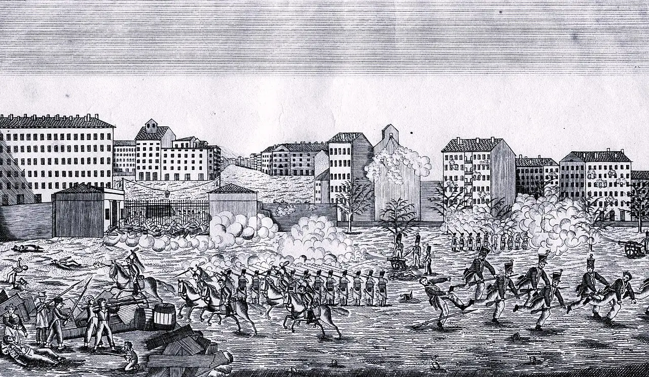 Gravure en noir et blanc : sur une place bordée d'immeubles, des soldats à pied et à cheval avancent dans la fumée des tirs ; à gauche, des civils armés s'abritent derrière des tonneaux et des planches, des corps gisent au sol.